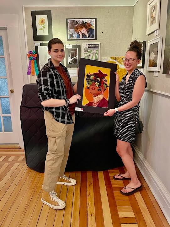 Award-winning artist Giavanna Zavala of Bayport-Blue Point High School presents her recently purchased work to what is the first of many patrons of her art.